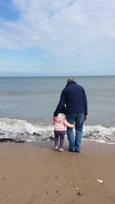 picture of the grandad and girl are on a beach