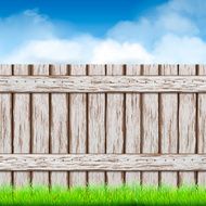 wooden fence with green grass and blue sky