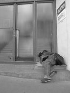 the homeless man lies on the steps at the entrance