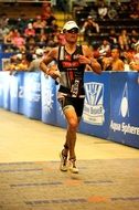 triathlon, male runner in front of spectators