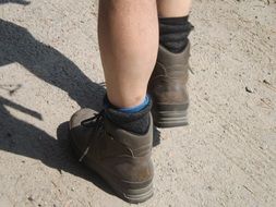 Brown hiking boots on the legs on a sunny day