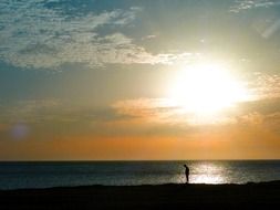 distant view of a lonely man at sunset