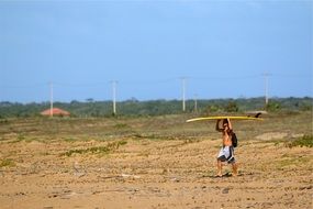 man holds a surfboard on his head