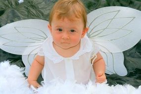 child in a white angel costume with wings