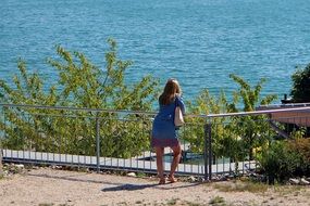 woman at the fence on the coast