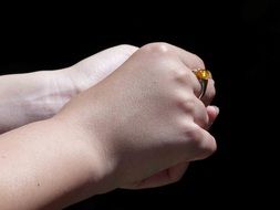 ring with a yellow stone on his hand
