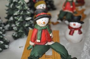 snowman riding on sled, christmas decoration