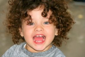 curly-haired child with mouth open