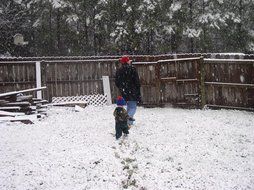 father with a child in a snowy yard