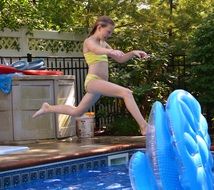 girl jumps into the pool