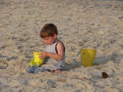 child with toys on the beach