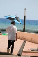 man walking with a sun umbrella