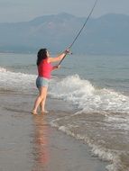 woman fishing sea beach sunset