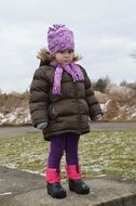 girl in winter clothes hills in snow