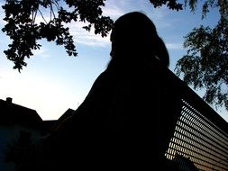 silhouette of a man resting on a bench