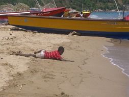 boy lying on the wet sand of the beach