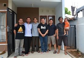family stands near the house
