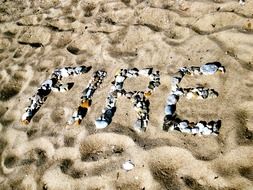 letters of shells on the sand