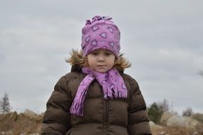 nice child in pink hat winter walk