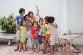 children with brooms on the street in Thailand