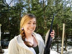 girl with a weapon on the background of the forest