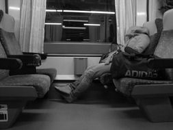 man sleeping in train monochrome photo