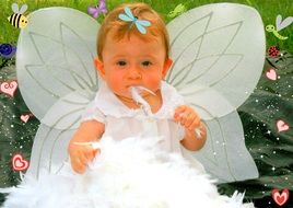 Portrait of a toddler in a white dress with angel wings