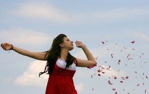 girl on the background of flying red petals