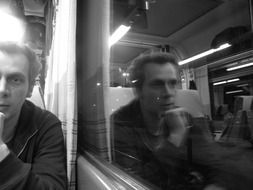 man at the window in the train black and white photo