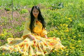 girl in a yellow dress on a background of flower field