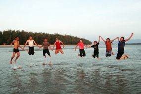 happy jumping friends on the beach