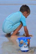 child playing with sand on beach