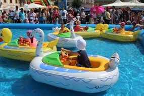 children ride on inflatable games in the pool