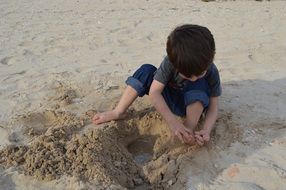 child boy playing on sand