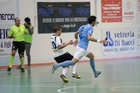 Man falling while playing indoor football