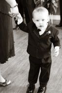 a little boy in a nice tuxedo.