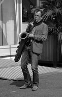 Black and white photo of Street Artist plays on a saxophone
