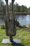 upside down man, contemporary statue in park at water