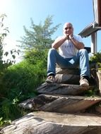 Man is sitting on the wooden ladders
