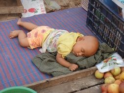 sleeping tired child in a bazaar in myanmar