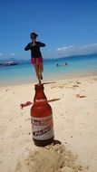 creative photo with a bottle of beer on the summer beach