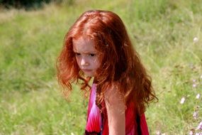 a child with red hair on the nature background