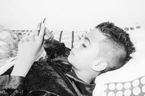 black and white photo of a boy with a smartphone in his hands