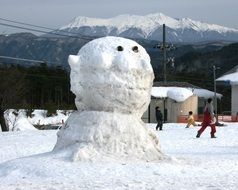 big snowman in view of mount kurai, japan