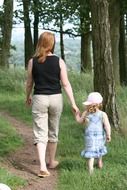 mother and daughter walk in the forest