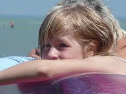 girl swims on an inflatable mattress on Lake Balaton