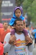 child on the neck of the parent