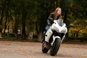 blonde in leather jacket goes on a motorcycle
