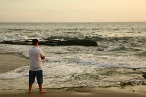 landscape of man near the surf on the beach in california