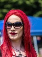 man with bright makeup and red hair at a gay parade